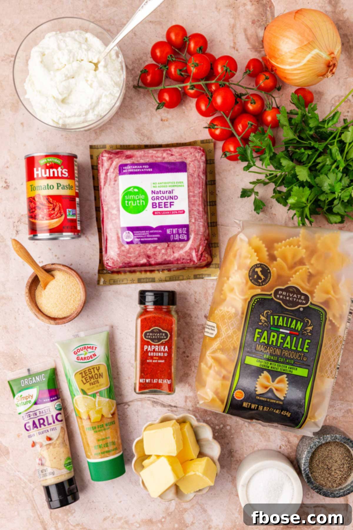 Overhead photo of fresh ingredients to make Turkish pasta laid out on a wooden table.