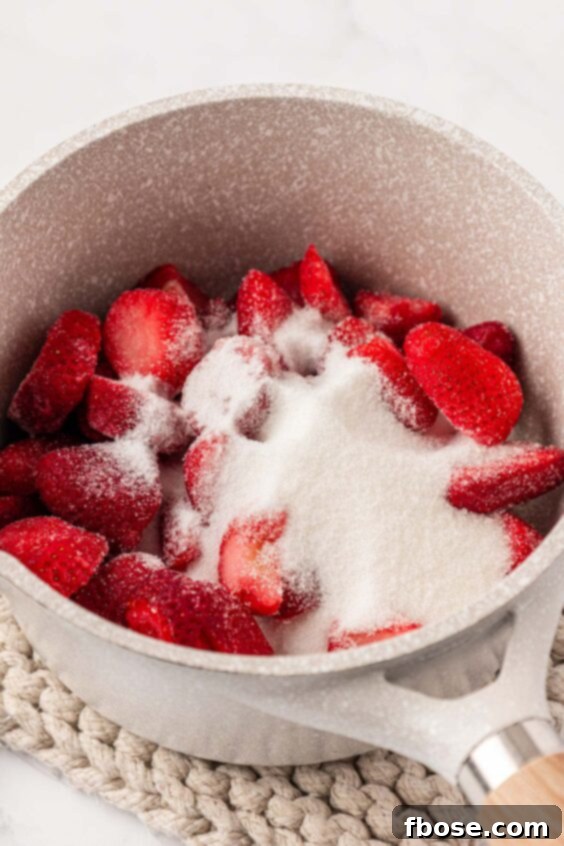 Strawberries and sugar in a pot.