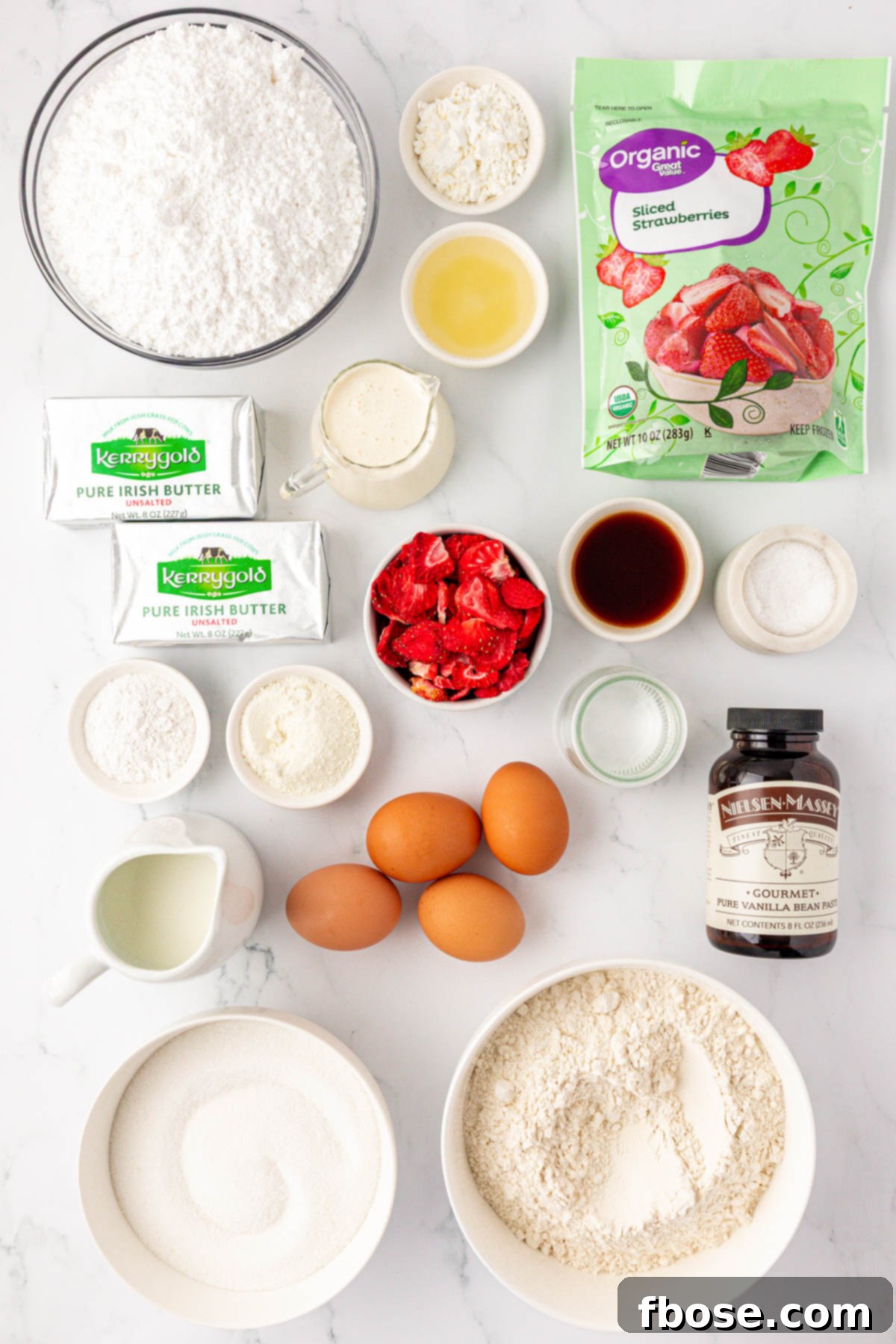 Overhead photo of ingredients to make strawberry vanilla cake on a table.