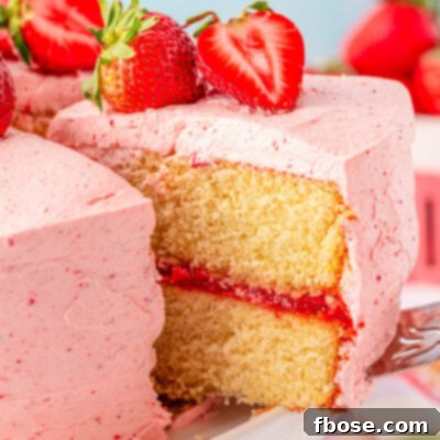 A slice of strawberry cake being lifted off a white cake stand.