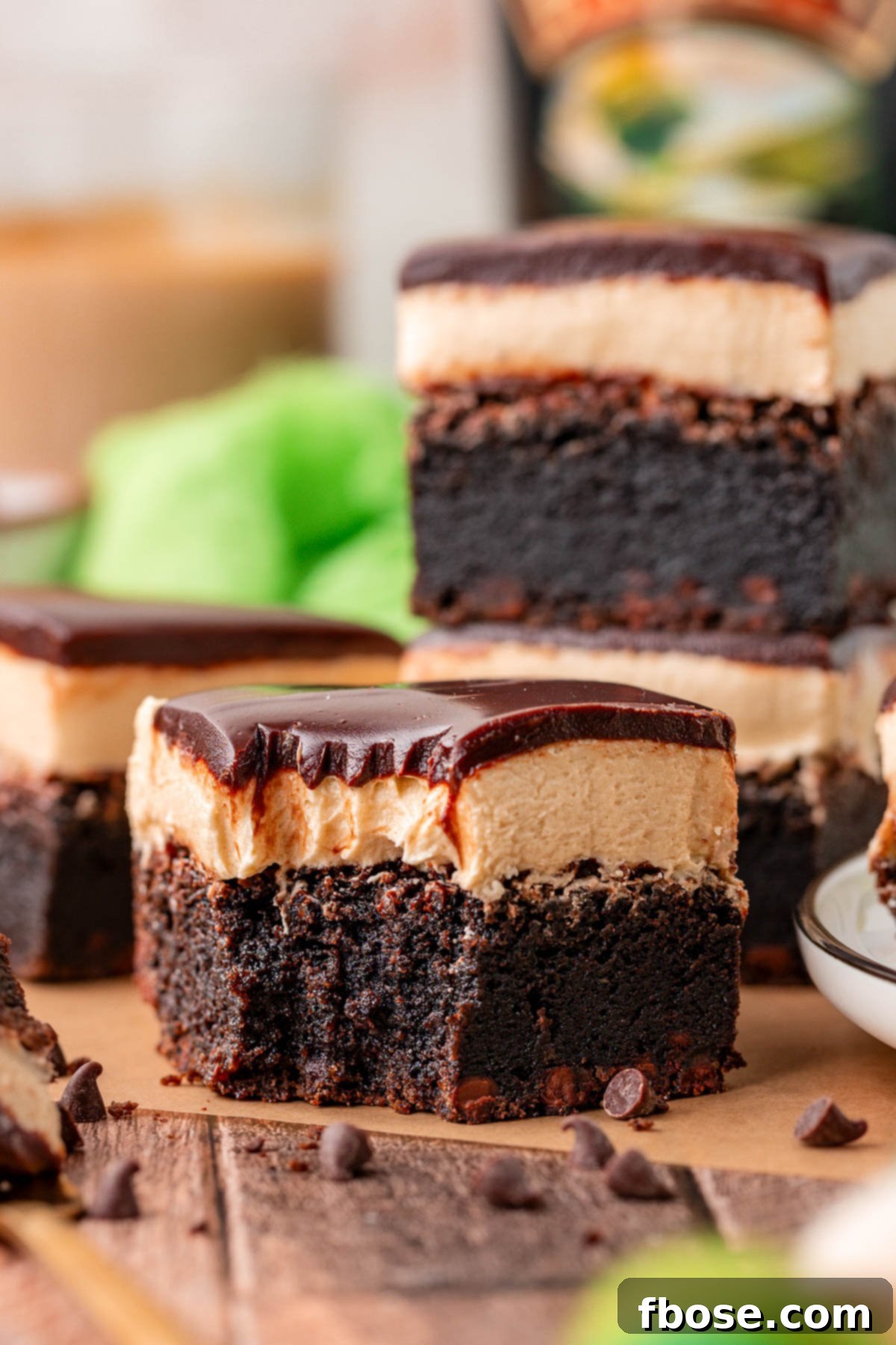 Close up of a Bailey's Brownie on a piece of parchment paper with a bite taken out of it.