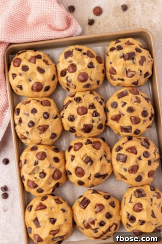 Overhead photo of balls of chocolate chunk cookie dough on a baking pan ready to chill, showing proper spacing.