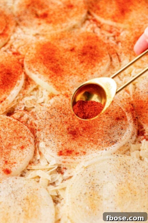 Spices being sprinkled on onion slices.