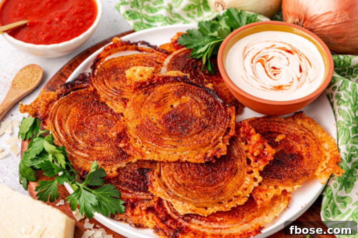 Onion ring chips artfully arranged on a white plate with a side of creamy dipping sauce.
