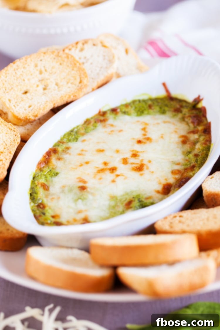 Baked Spinach Artichoke Dip ready to serve with dippers.