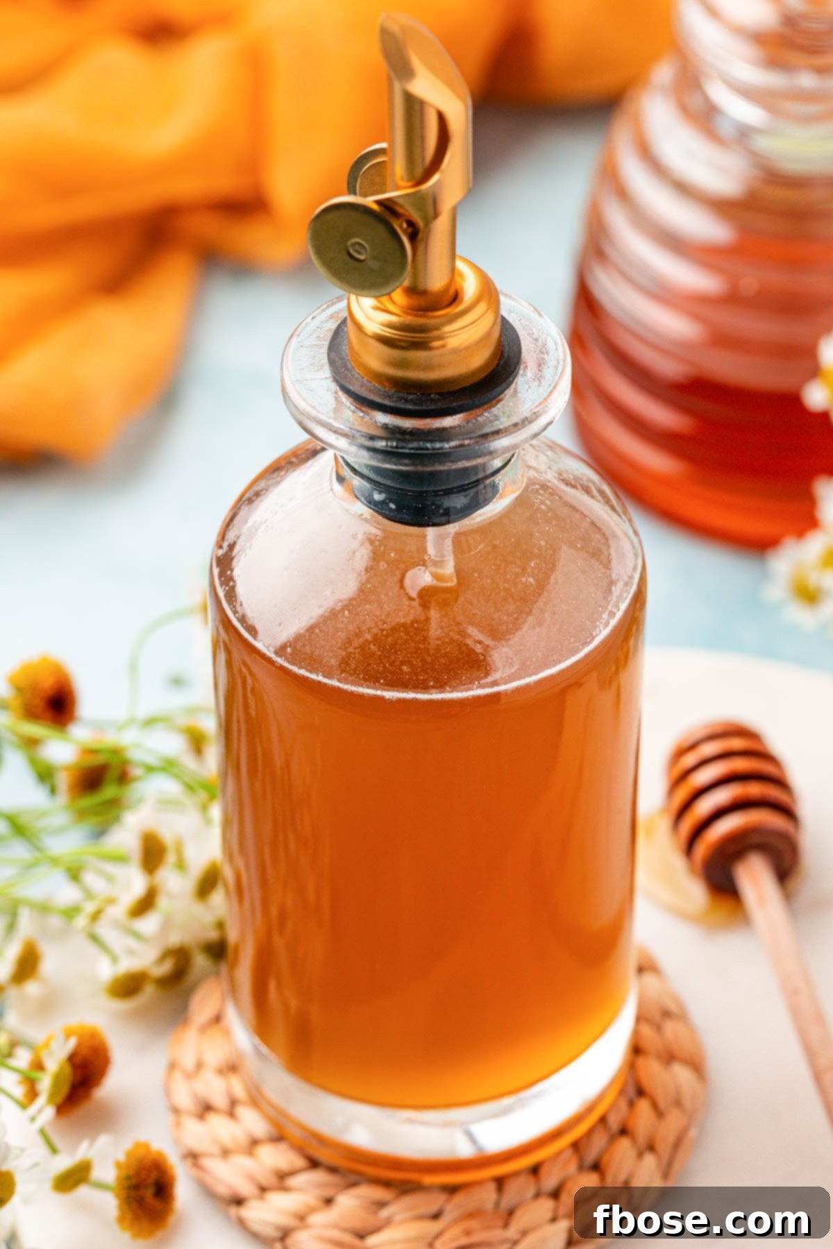 A elegantly bottled honey simple syrup on a wooden table, emphasizing its readiness for use.