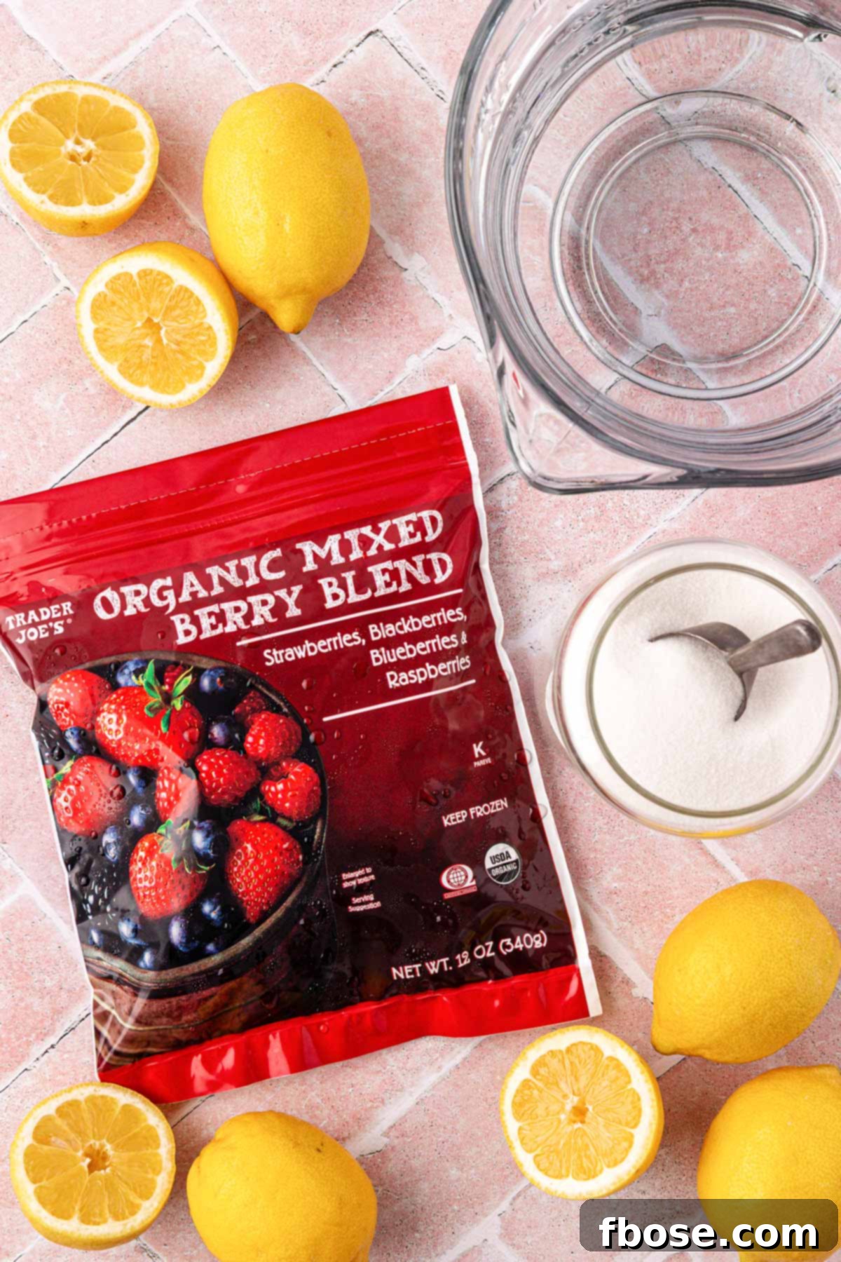 Ingredients to make berry lemonade on a table.
