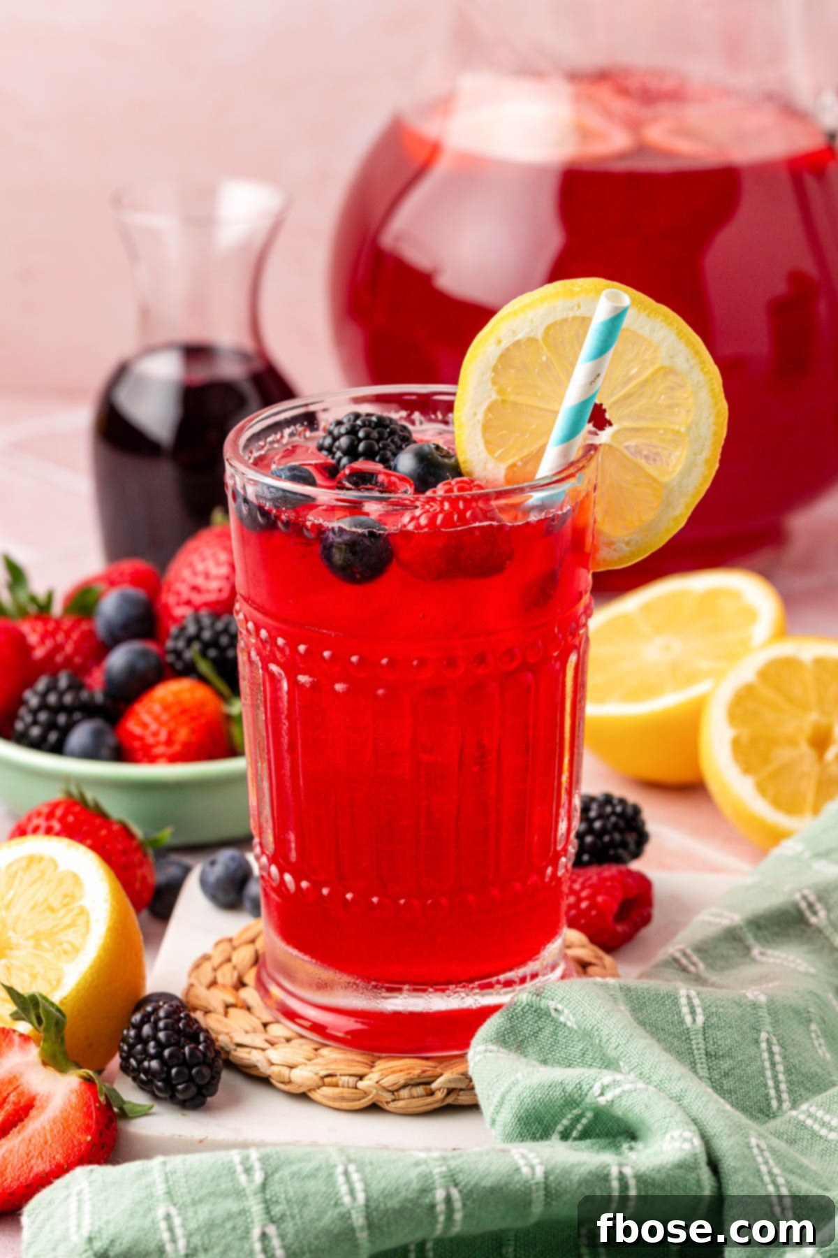 A glass with berry lemonade in it.