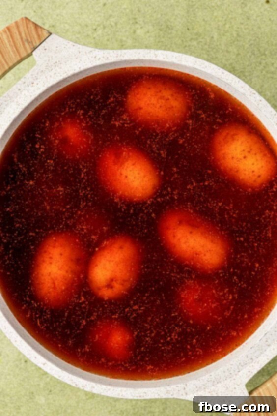 Potatoes in a pot with seasonings and water.