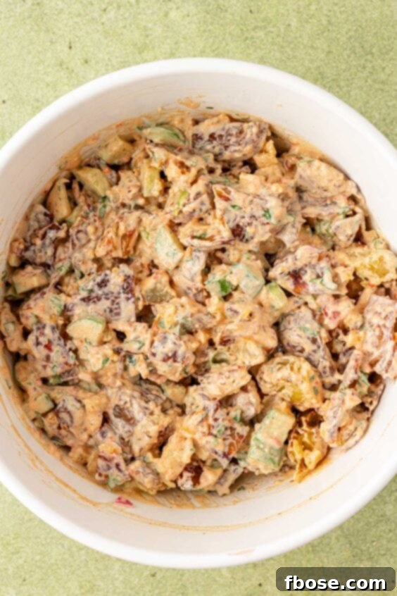 Chili Crisp potato salad coated in dressing in a bowl.