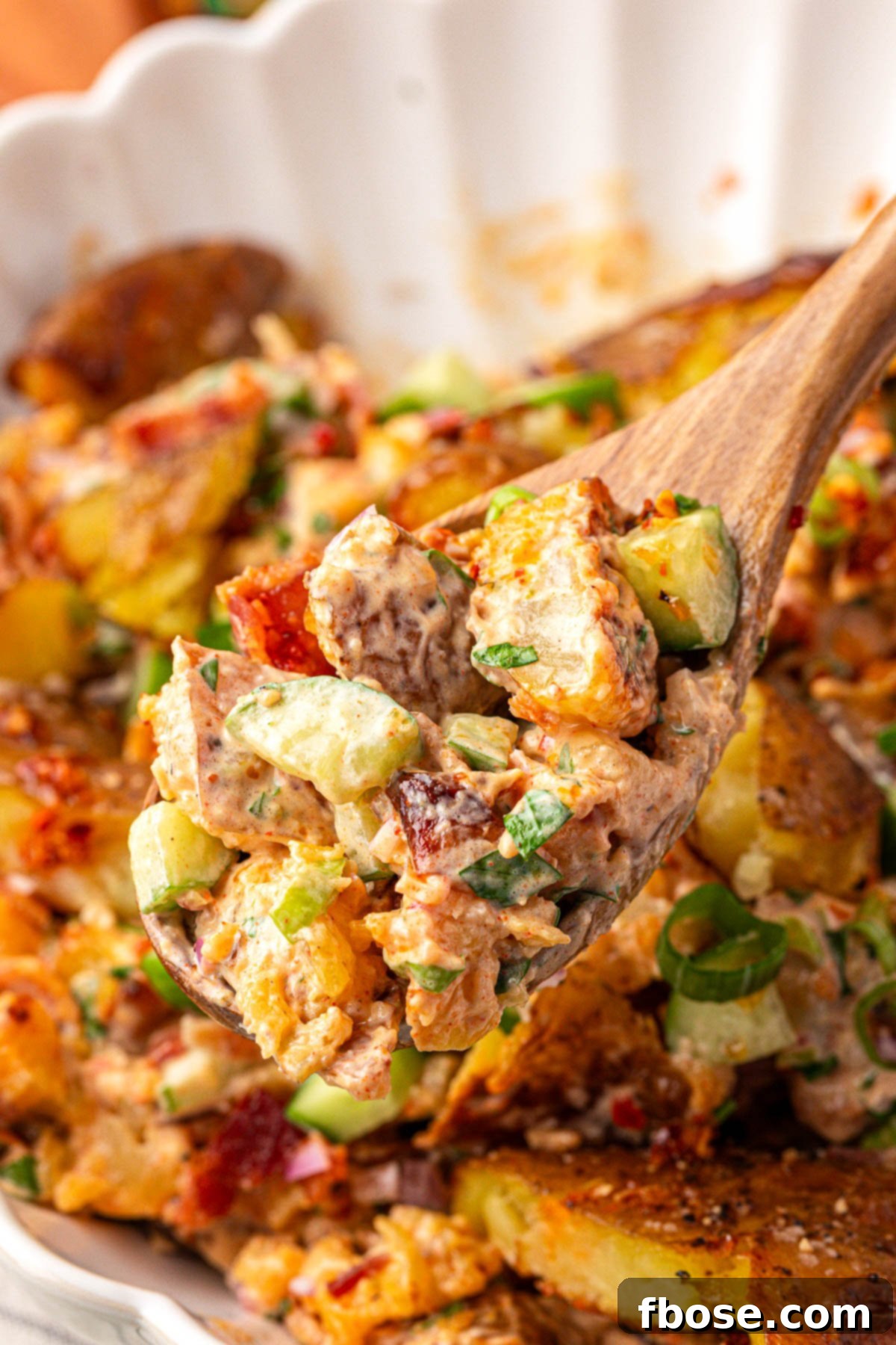 A serving spoon with a scoop of chili crisp potato salad.