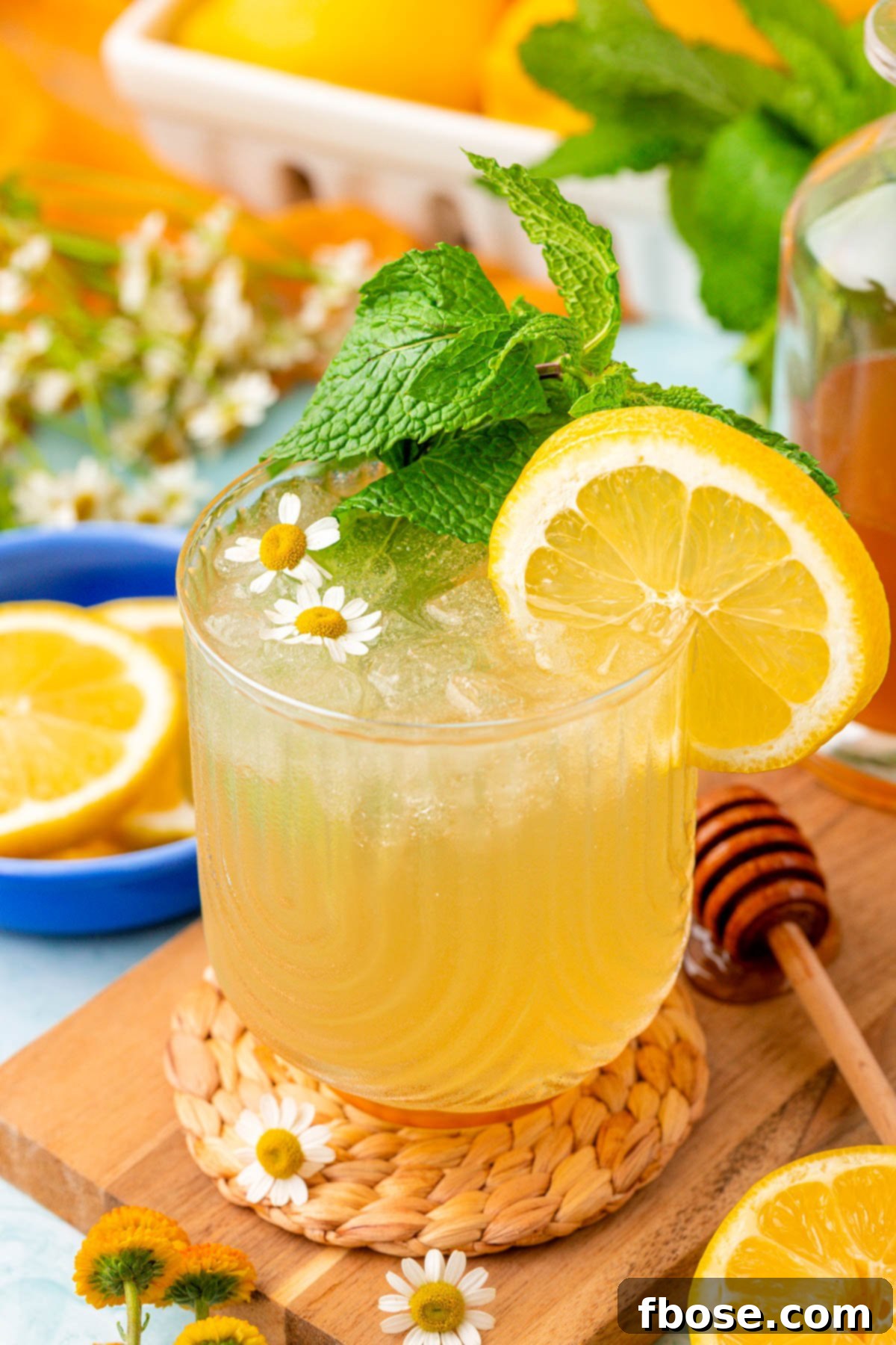 Zesty Honey Delight 2 Close up of a glass of honey lemonade on a table, garnished with a lemon slice.