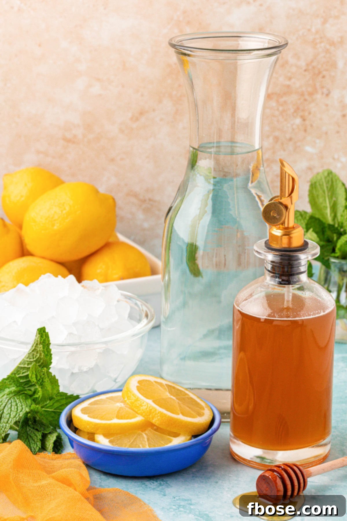 Zesty Honey Delight 4 Ingredients for homemade honey lemonade laid out on a blue table, including lemons, a jar of honey, and a glass of water.