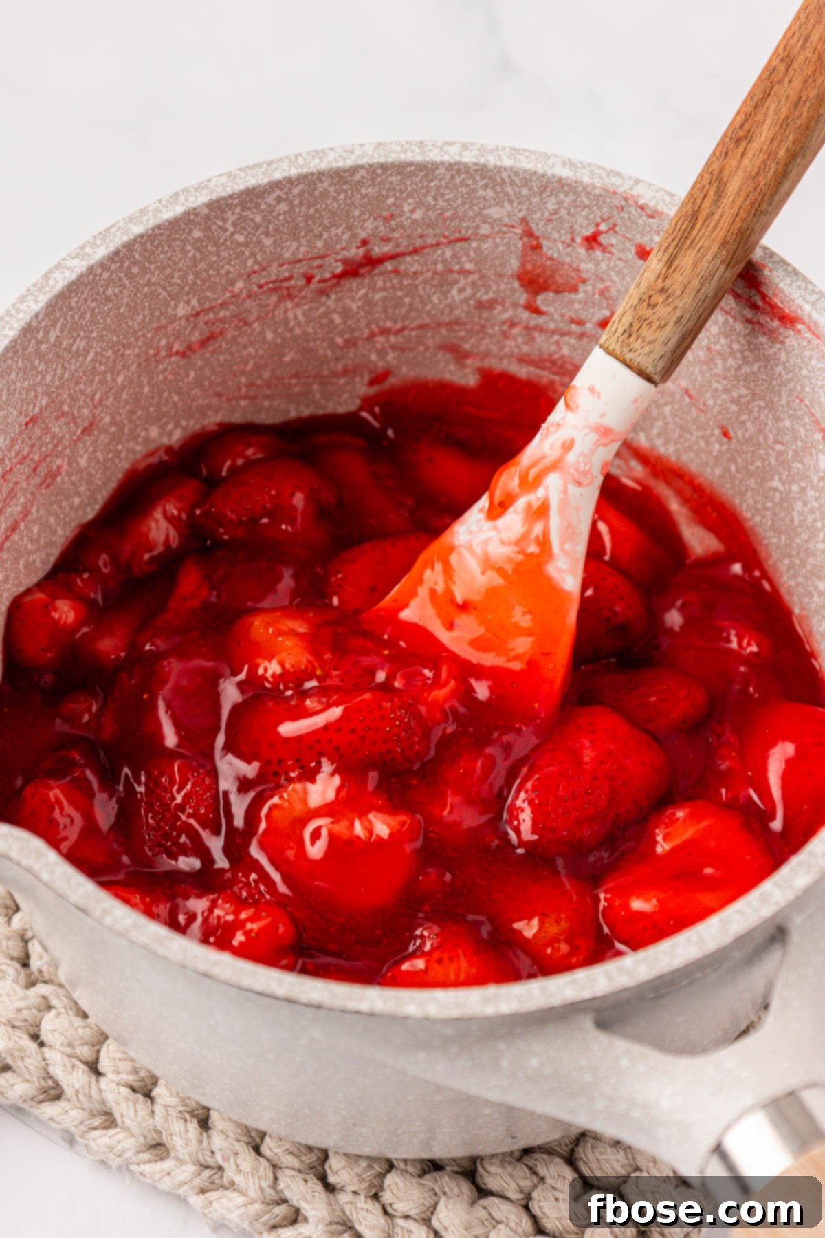 Close up of a pot filled with strawberry cake filling.