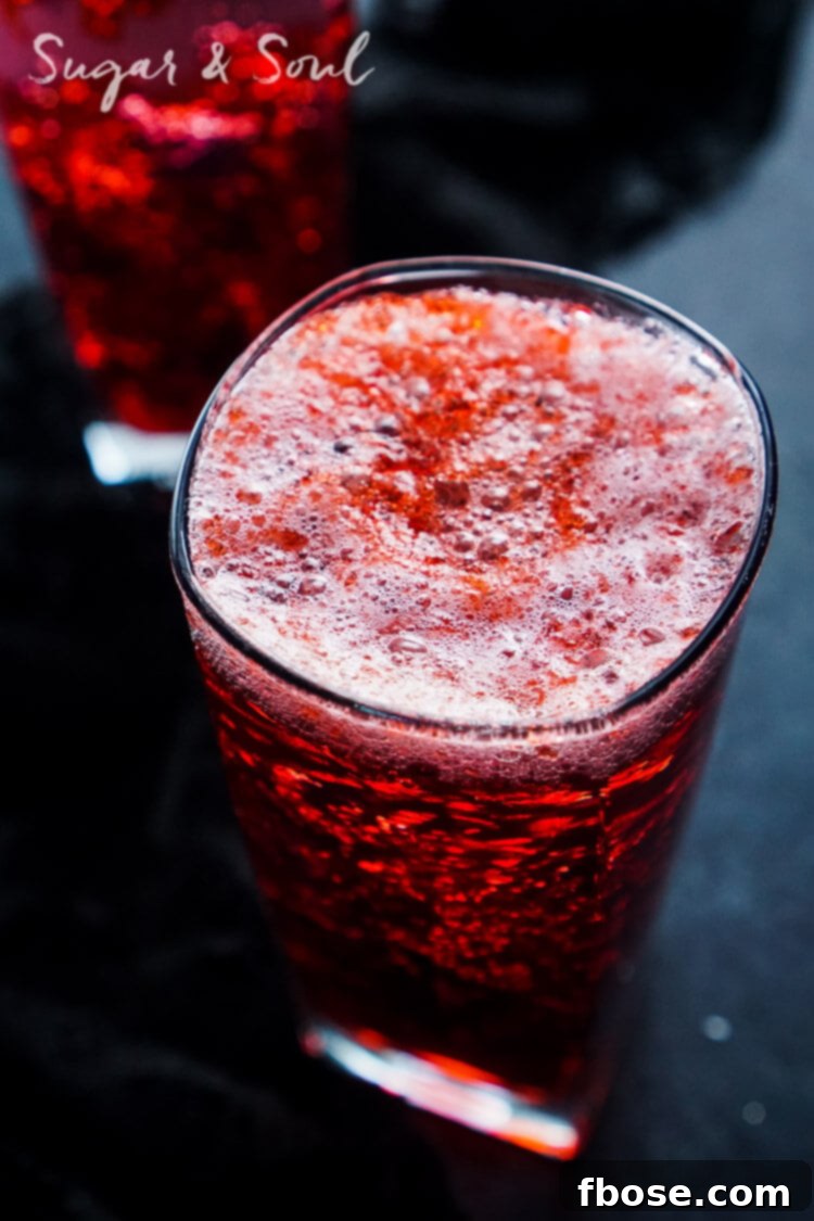 Close-up of the Blood and Guts Cocktail, showcasing layers of red jello and dark liquid in a tall glass, garnished for a horror theme.
