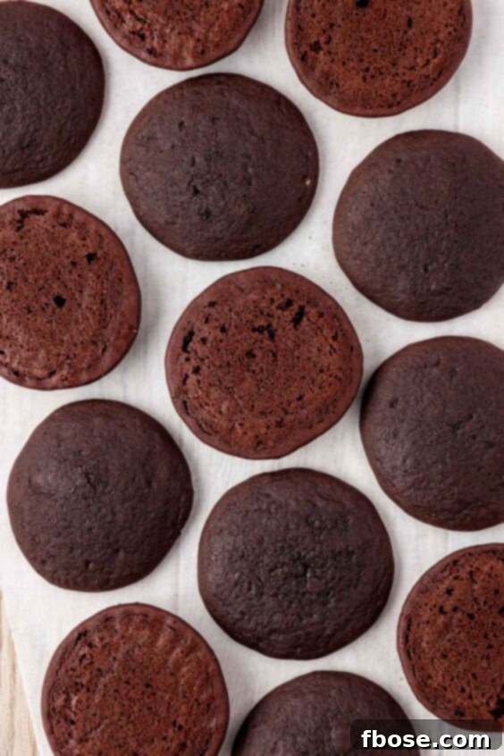 Chocolate cakes for whoopie pies on a parchment-lined pan.