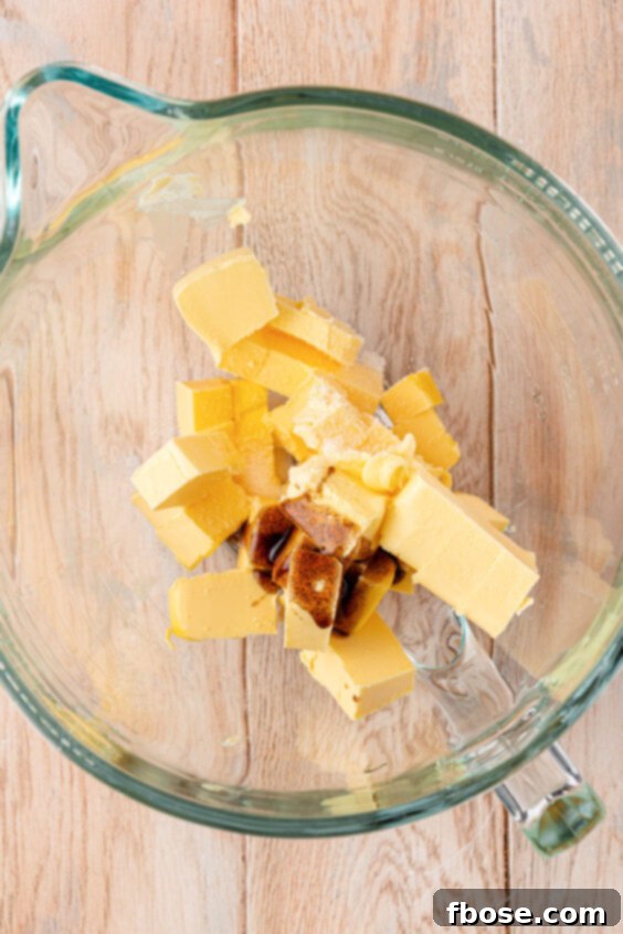 Butter and vanilla in a stand mixer ready to be mixed.