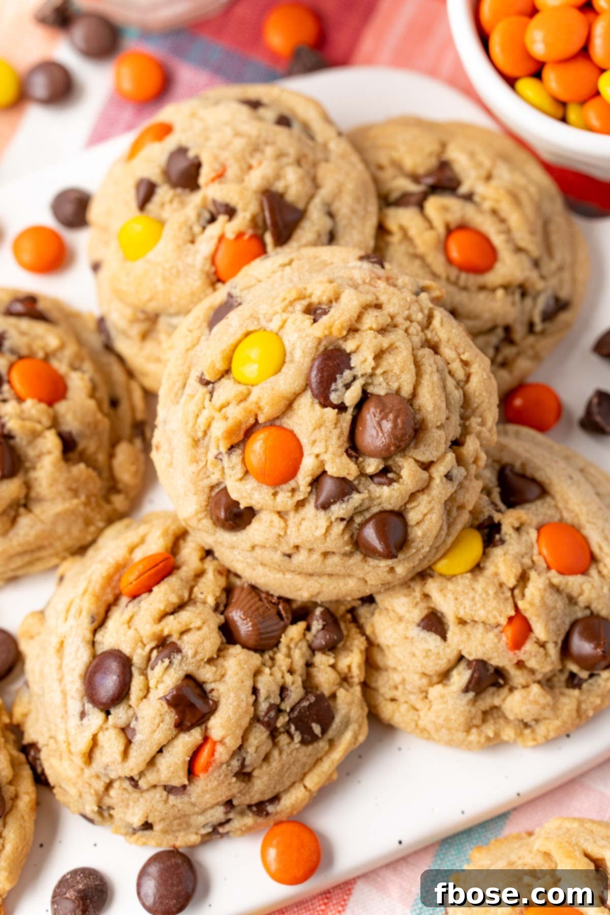 Peanut Butter chocolate chip cookies with reese's pieces on a white serving tray.