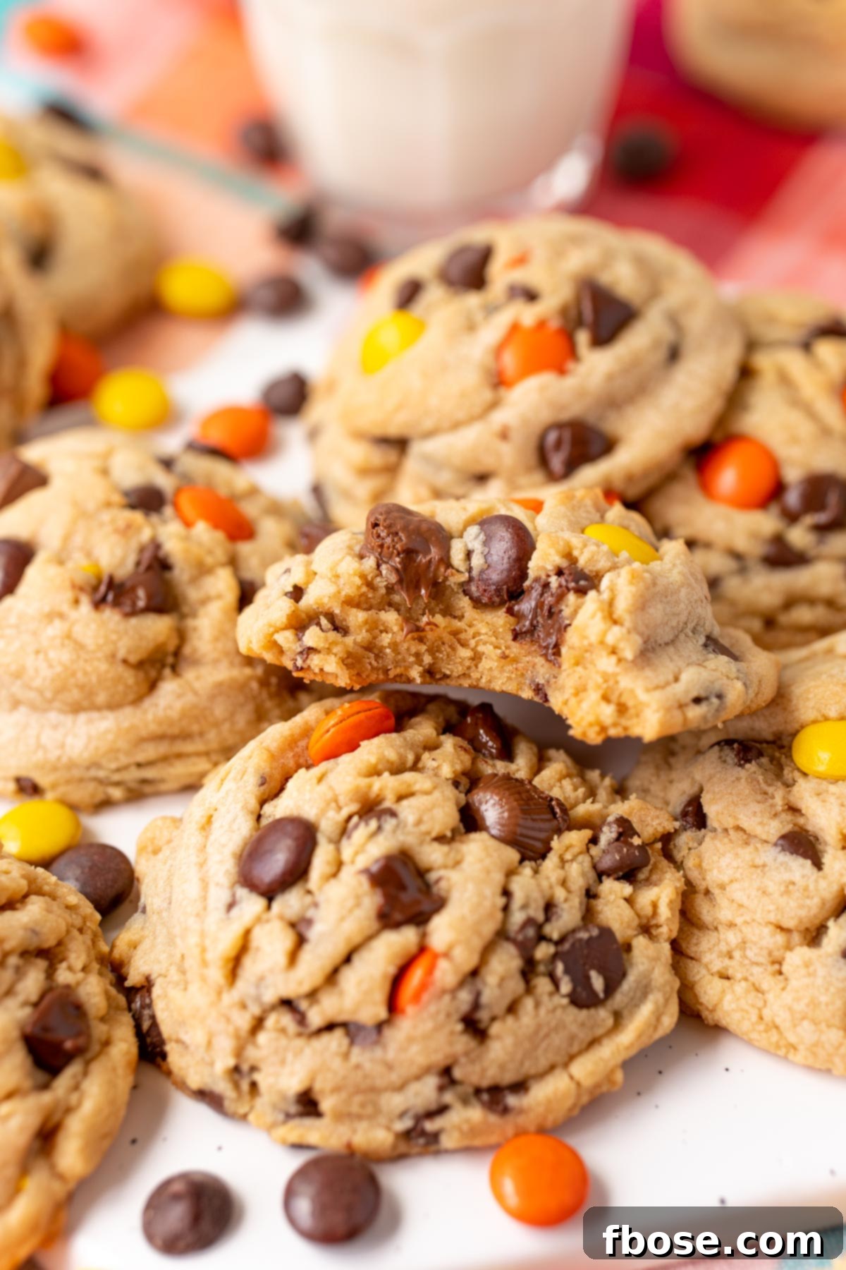 Reese's Pieces Peanut Butter Cookies on a serving tray, one has a bite taken out of it.