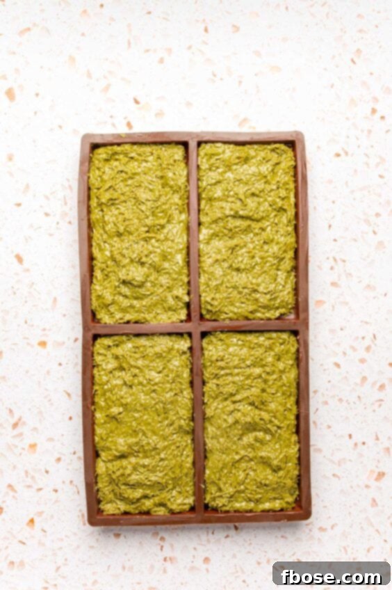 Dubai bar filling being pressed into a chocolate mold.