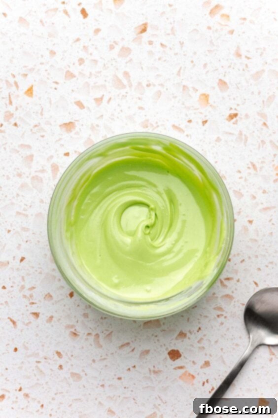 Green colored white chocolate in a small bowl.