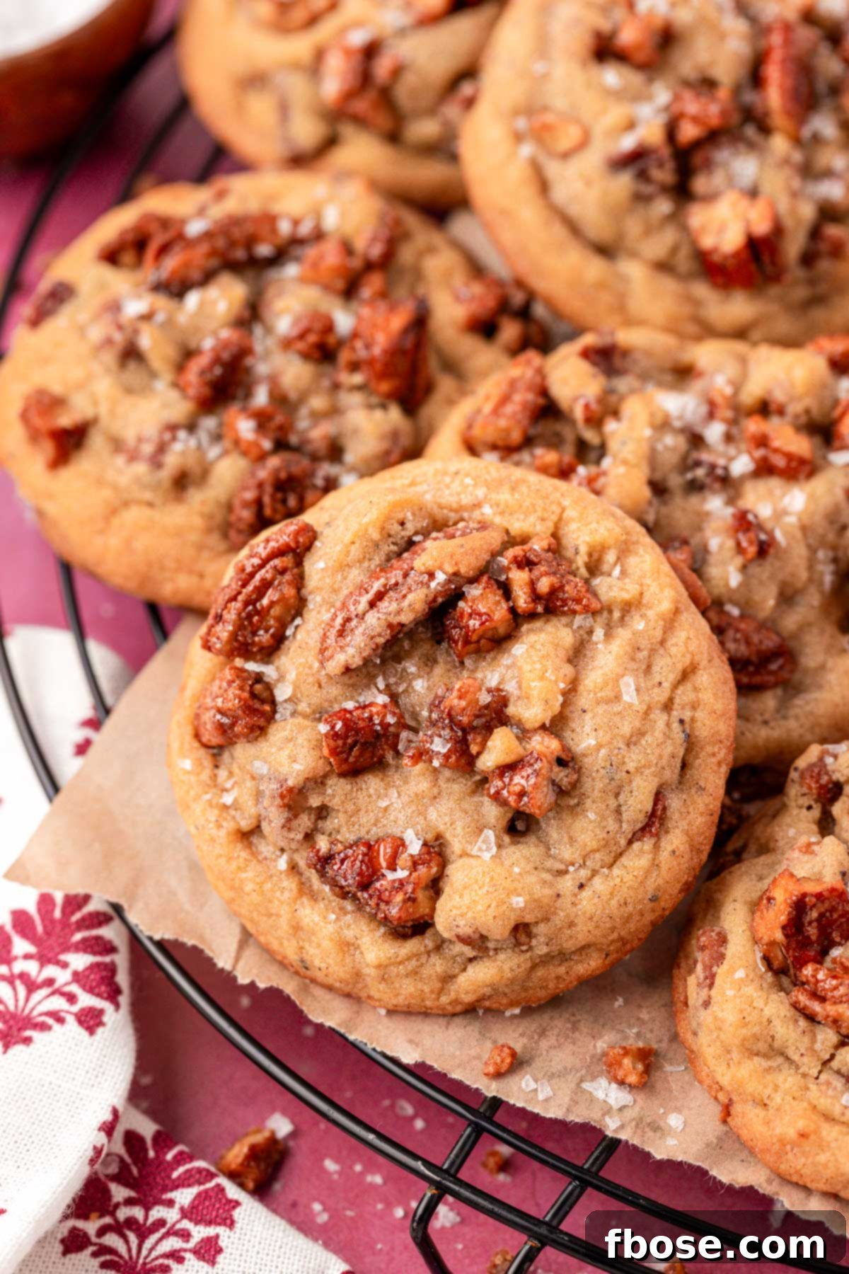Delicious Brown Butter Maple Pecan Cookies artfully arranged on a wire cooling rack.