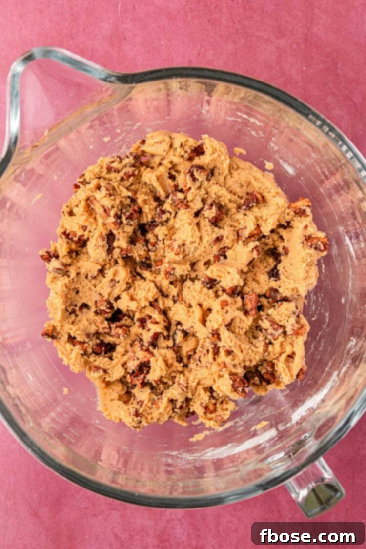 Another perspective of the cookie dough, emphasizing the incorporation of ingredients.