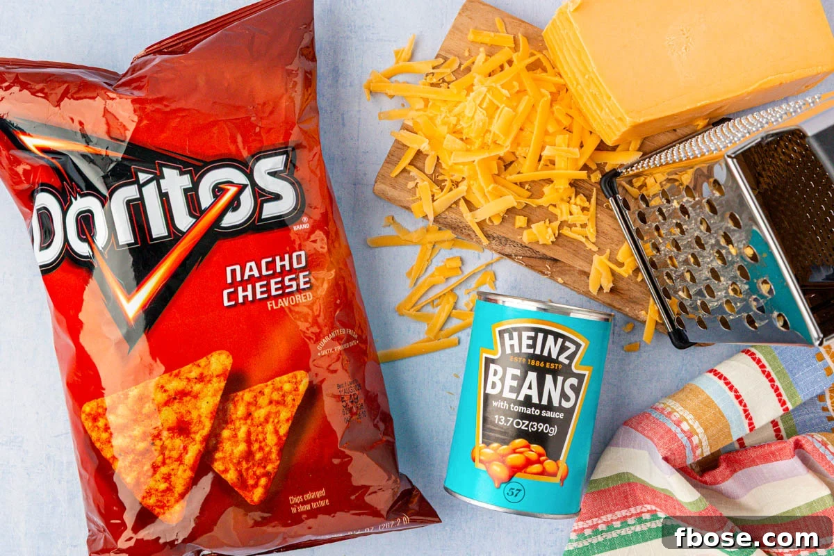 A bag of Doritos, a can of baked beans, and a block of cheese on a table.